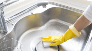 An image of a Kitchen Sink being scrubbed | 5 Ways To Keep Your Kitchen Sink Sparkling