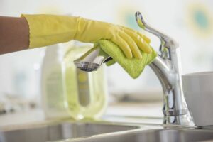 An image of a Kitchen Tap Being Cleaned | 5 Ways To Keep Your Kitchen Sink Sparkling